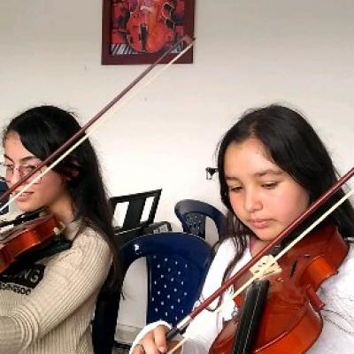 Jóvenes estudiantes en clase de violín de la E.M Amadeus.