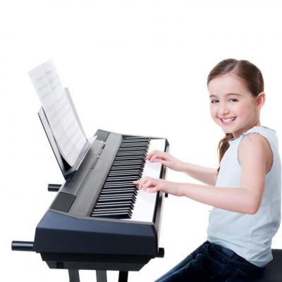Imagen niña tocando un teclado o piano electrónico.